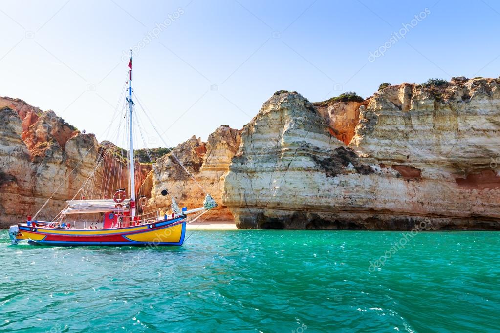 Ship in ocean with rocky cliff