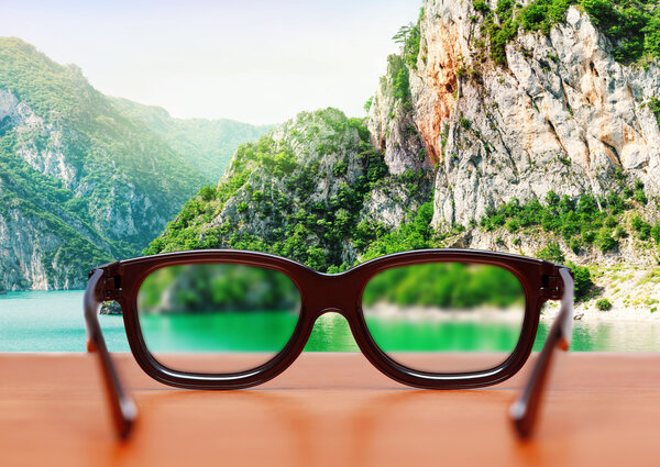 Eyeglasses on the table over mountain