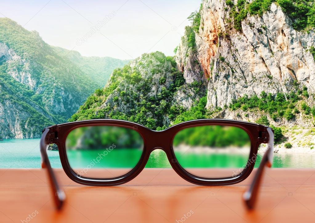 Eyeglasses on the table over mountain
