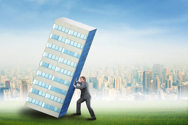 Businessman is constructing skyscraper — Stock Photo, Image