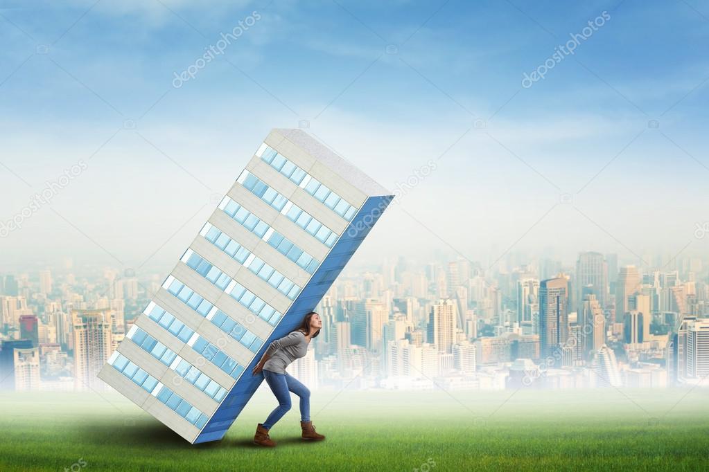Businesswoman is holding skyscraper