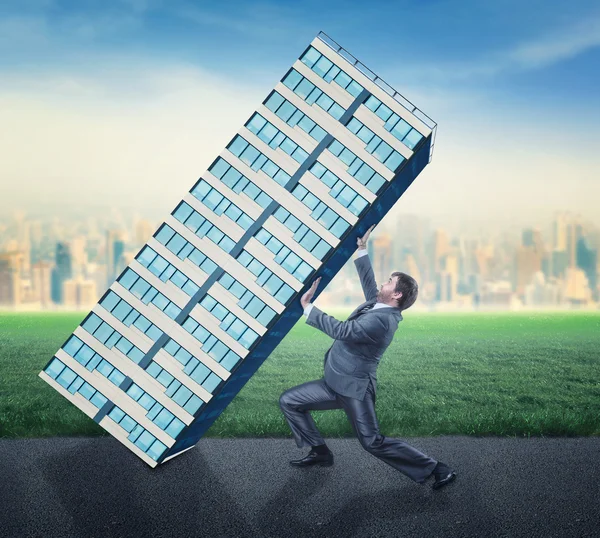 Businessman with falling skyscraper — Stock Photo, Image