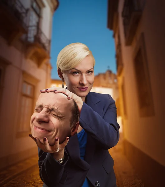 Kvinna med mannens huvud i handen — Stockfoto