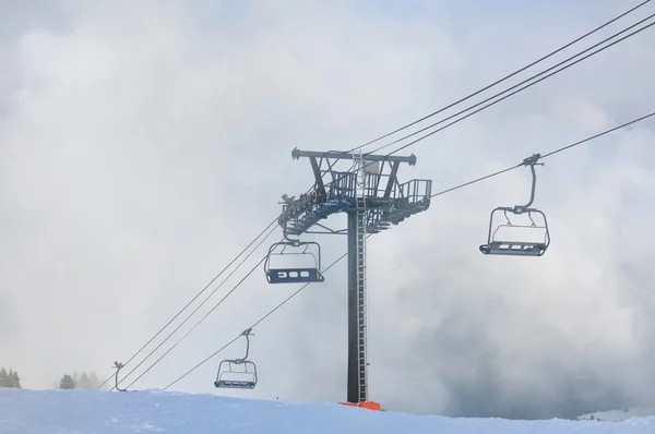 Chairlift in clouds in winter — Stock Photo, Image