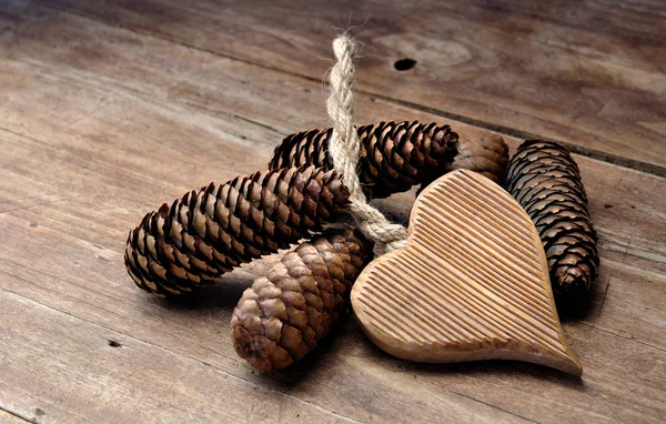 Wooden heart and pine cones — Stock Photo, Image