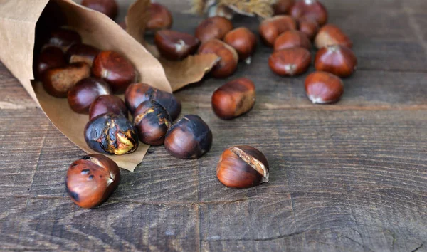 Castagne Arrosto Sacchetto Carta Versato Sul Tavolo Legno — Foto Stock