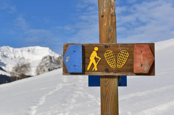 Teken Van Sneeuwschoenloop Een Besneeuwde Bergachtige Achtergrond — Stockfoto