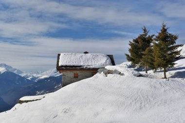 Karlı dağdaki vadiye bakan dağ evi. 
