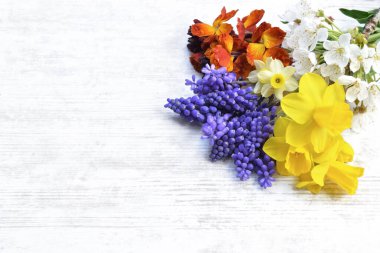 Beyaz masadaki bahçede toplanmış taze çiçekler. 