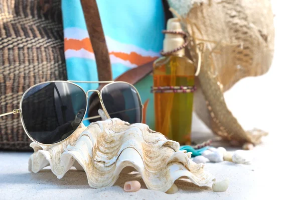 Zonnebril, schelpen en strand tas. — Stockfoto