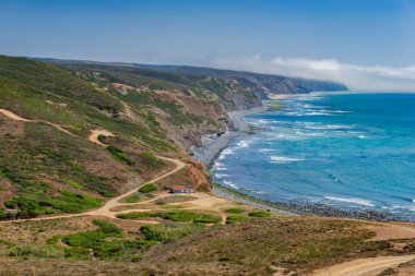 Portekiz 'in Algarve bölgesindeki Aljezur' da kirli bir yolu olan Atlantik Okyanusu 'ndaki bir sahil ve sahil manzarası