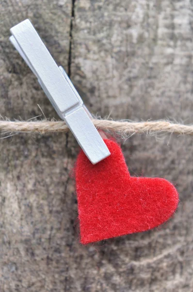 Pequeno coração vermelho pendurado em uma corda — Fotografia de Stock