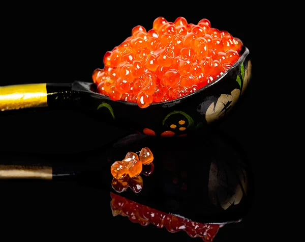 A colher com caviar vermelho em um fundo preto — Fotografia de Stock