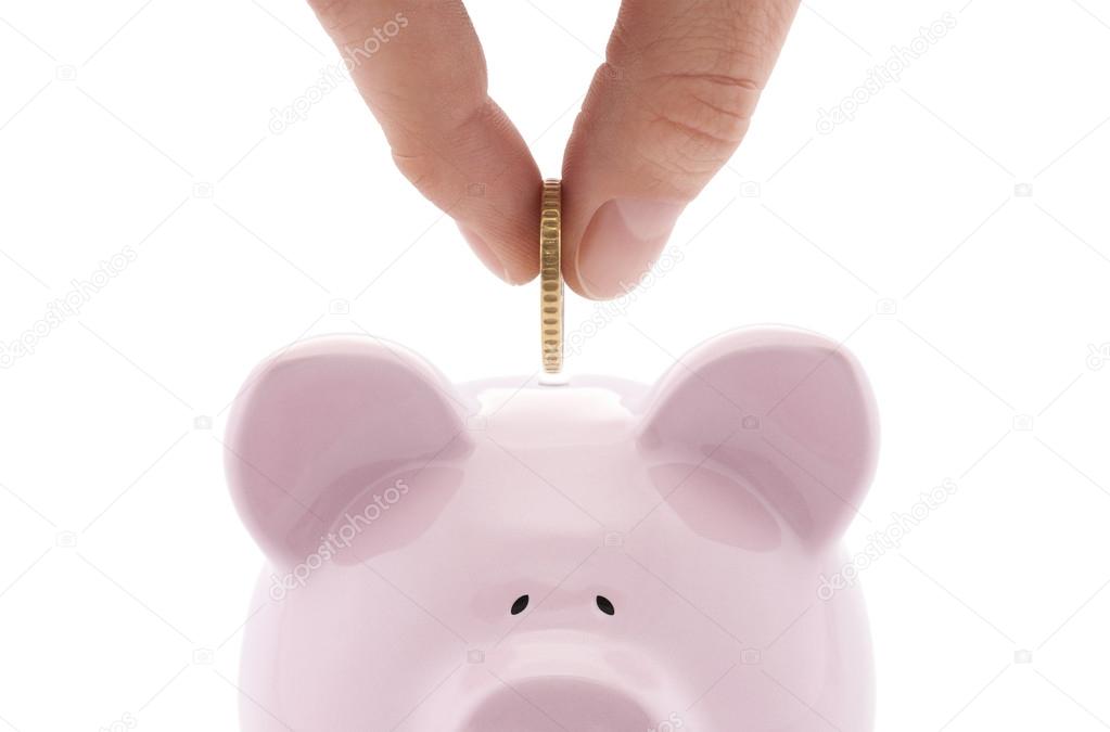 Putting coin into the piggy bank