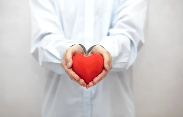 Corazón rojo en las manos — Foto de Stock