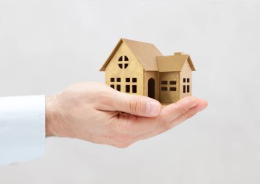 Gri arka planda altın ev minyatürü