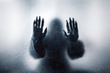 Pençeleri olan bir canavar Tozlu bir camın arkasında