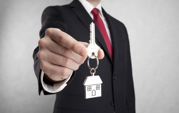 House key in businessman hand with clipping path — Stock Photo, Image