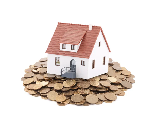 Small toy house on a pile of coins — Stock Photo, Image