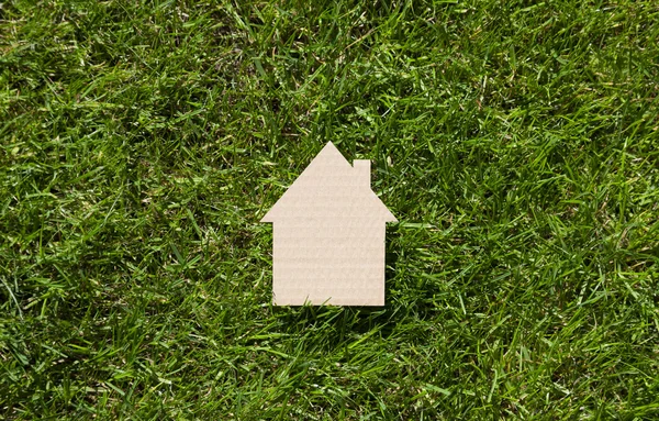 Cardboard house on green grass — Stock Photo, Image