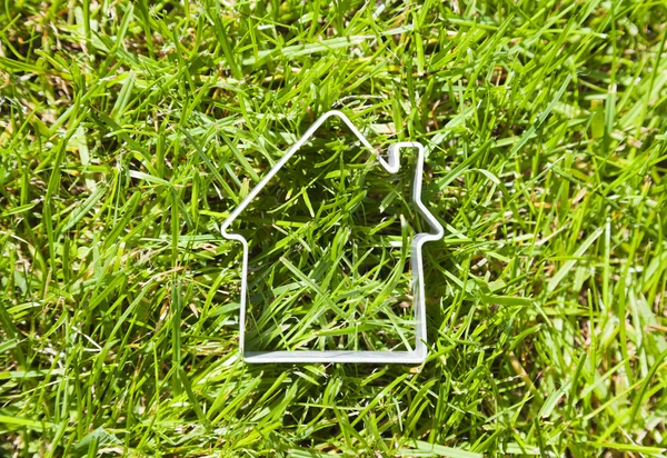 Kształt domu na zielonej trawie — Zdjęcie stockowe