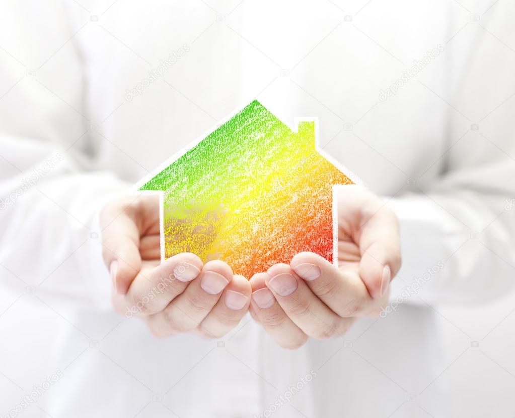 Drawing of colorful house in hands. Energy saving concept.