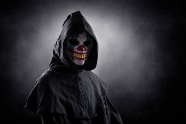 Karanlık sisli arka planda kırpma yolu olan korkunç bir palyaço portresi.