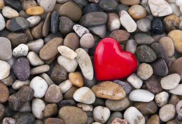 Rött hjärta på pebbles bakgrund — Stockfoto