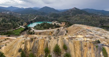 Kıbrıs Rum Kesimi 'nin Xyliatos kentindeki terk edilmiş Memi madeni yerine renkli bakır madenleri ve göl yığınları. Uzak dağları olan hava manzarası 