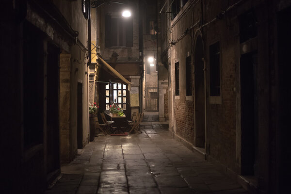 Cozy restaurant in an alley at night in Venice