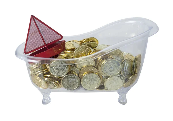 Badkuip gevuld met gouden munten en een rode boot — Stockfoto