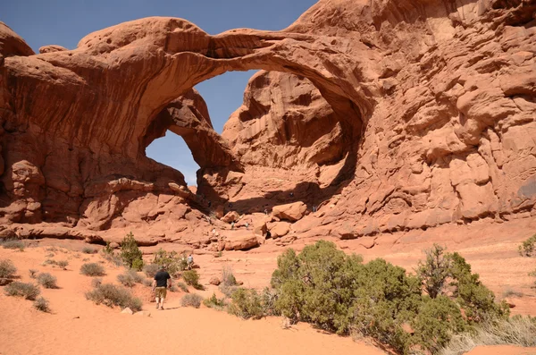 Туристы на Double Arch в Arches NP — стоковое фото