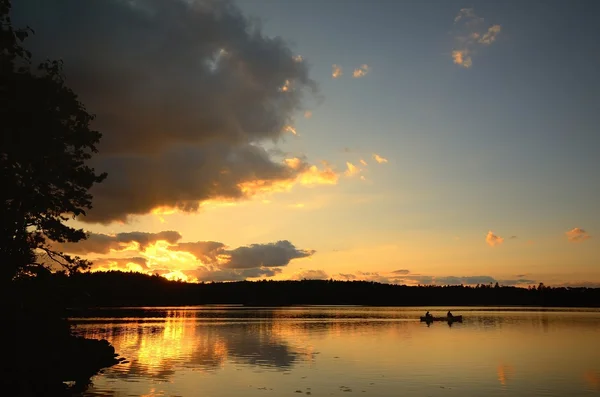 Canoa al tramonto su un lago selvaggio Immagini Stock Royalty Free