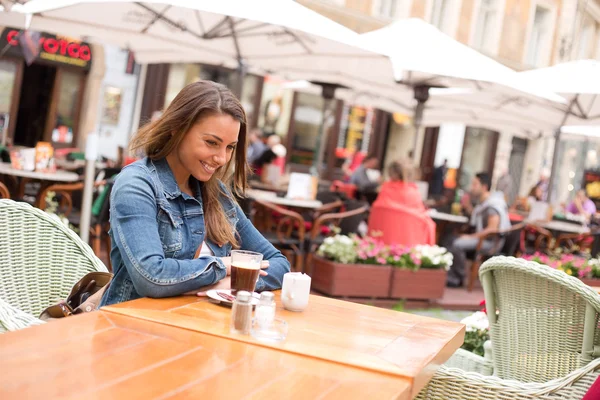 Ung kvinna på en restaurang med en kaffe — Stockfoto