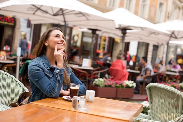 Ung kvinna ser fundersam på en restaurang — Stockfoto