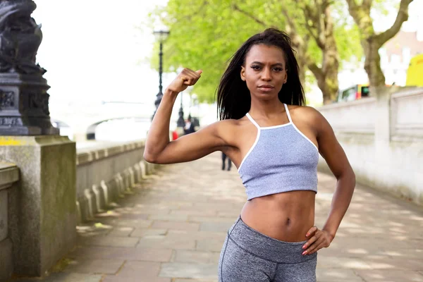 Fitness kvinde viser hendes muskler - Stock-foto