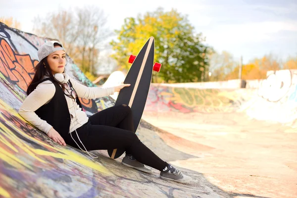 Молодая женщина со скейтбордом — стоковое фото