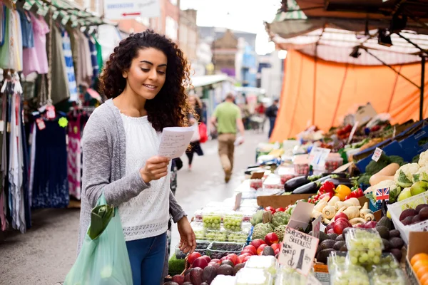 Genç kadın bir semt pazarı gıda için alışveriş — Stok fotoğraf