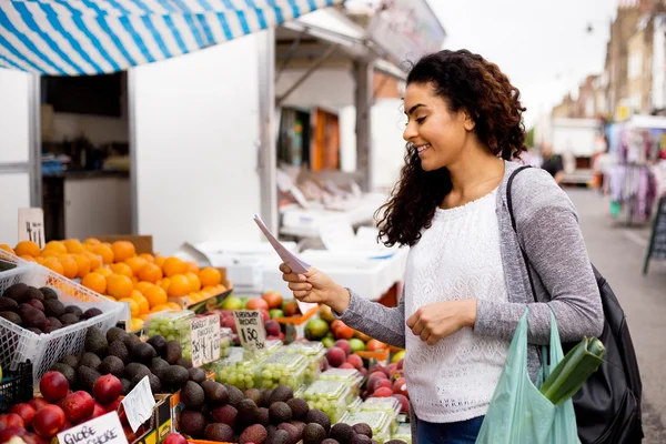 Mujer joven comprando comida en un mercado callejero — Foto de Stock