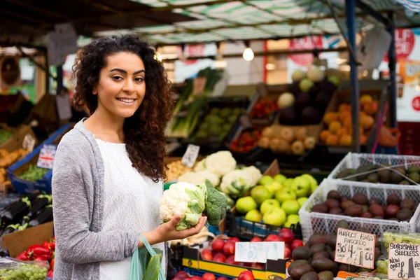 Mujer joven comprando comida en un mercado callejero — Foto de Stock