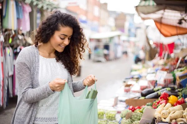 Mujer joven comprando comida en un mercado callejero — Foto de Stock