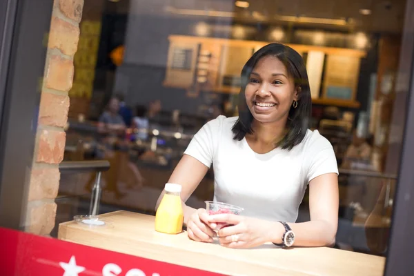 Jonge vrouw zitten in een koffieshop — Stockfoto