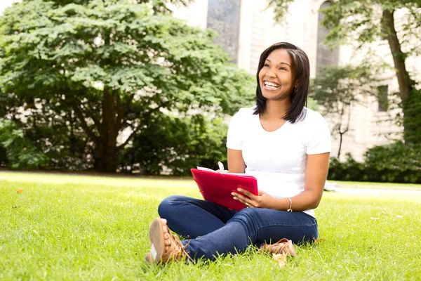 Happy girl sitting in the park doing paperwork — Stock Photo, Image