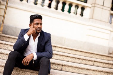 basamaklarında oturan dalgın Hintli adam