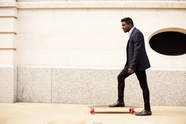 Индийский бизнесмен со скейтбордом — стоковое фото