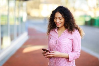 Sokakta evini kullanan genç bir kadın.