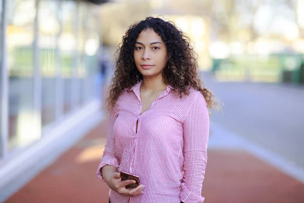 携帯電話を持っている若い混合人種の女性の肖像画 — ストック写真