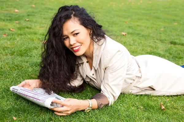 Reading newspaper in park — Stock Photo, Image