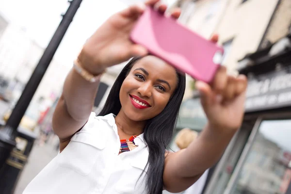 Ung kvinna som tar en selfie — Stockfoto