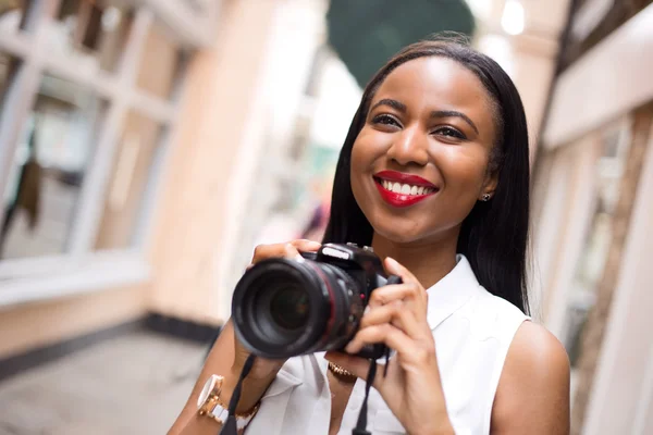 Jovem mulher segurando uma câmera — Fotografia de Stock